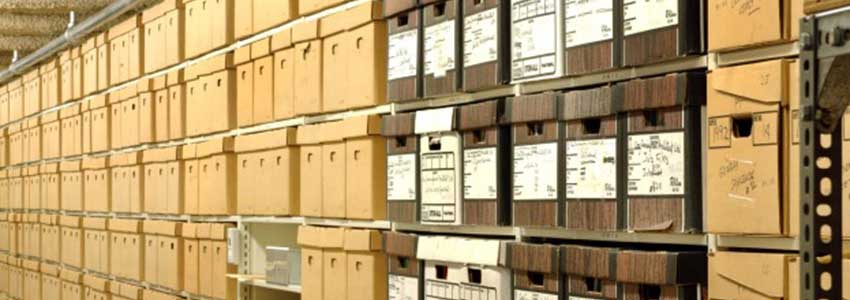 a row of metal shelves filled with archival boxes